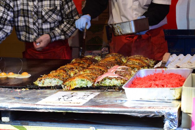 A bustling street food market in Seoul, with vendors selling various Korean delicacies like Tteokbokki, Kimchi, and Hotteok, capturing the essence of Korean street food culture.
