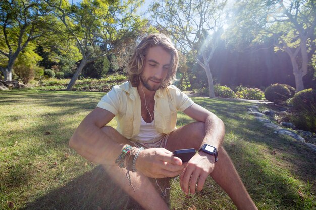 A person wearing a smartwatch and sitting in a peaceful garden, eyes closed, practicing a guided meditation. The smartwatch displays a calming image of nature and provides instructions for the meditation.