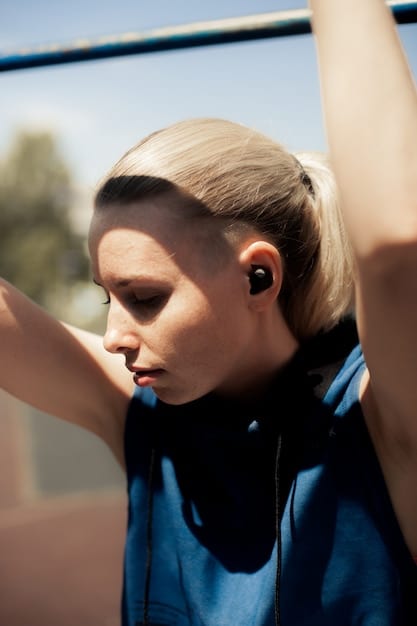 Close-up shot of a person wearing wireless earbuds while jogging outdoors, with focus on the earbud's secure fit and design.