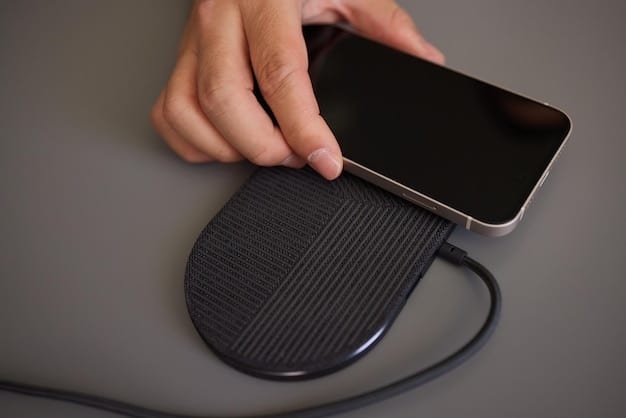 A close-up shot of a Qi-enabled smartphone charging on a wireless pad, highlighting the charging indicator on the phone's screen and the sleek design of the charging pad.