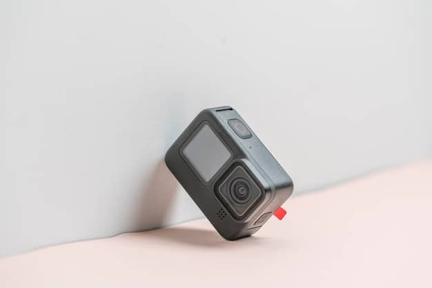 An action camera with a detachable battery pack, showcasing its extended battery life. The camera is mounted on a drone, capturing aerial footage of a scenic coastline, highlighting the camera's versatility and long recording capabilities.